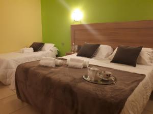 モンテジルヴァーノにあるホテル ラ ニンフェーアのベッド2台、テーブル、タオルが備わる客室です。