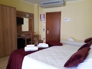 una camera d'albergo con due letti e asciugamani di Hotel La Ninfea a Montesilvano