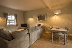 a living room with a large couch and a table at Eyam Cottage - Darwin Lake Holiday Village in Matlock