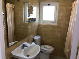 baño con lavabo y aseo y ventana en Apartaments Ocean Canada, en Platja d'Aro