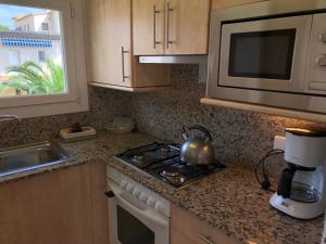 a kitchen with a stove and a microwave at Apartaments Ocean Canada in Platja d'Aro