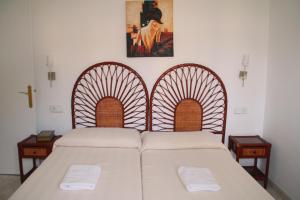 a bedroom with two beds and a painting on the wall at Apartaments Ocean Canada in Platja d'Aro