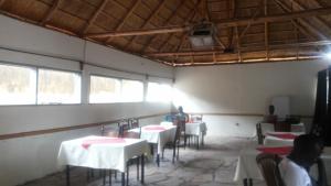 a room with tables and chairs and people sitting at them at Dubai Resort Hotel in Adjumani