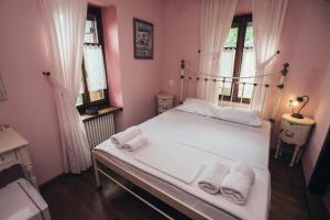 Un dormitorio con una cama blanca con toallas. en Ellis Full Guest House, en Tsagkarada
