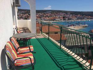 a balcony with chairs and a table and a view at Villa Strma in Primošten