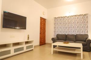 a living room with a couch and a tv at Surya Kiran Porvorim in Porvorim