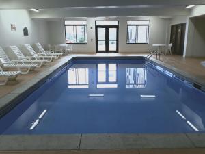 - une grande piscine avec des chaises dans un bâtiment dans l'établissement Wingate by Wyndham Dayton - Fairborn, à Fairborn