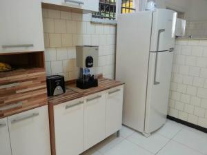 uma cozinha com armários brancos e um frigorífico branco em Arena Maracanã Hostel no Rio de Janeiro