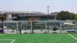 a building with a field of grass in front of a stadium at Arena Maracanã Hostel in Rio de Janeiro