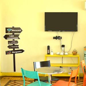 una habitación con una mesa y carteles en la pared en Arena Maracanã Hostel en Río de Janeiro