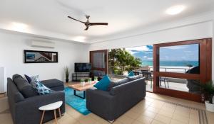 ein Wohnzimmer mit 2 Sofas und Meerblick in der Unterkunft Absolute Airlie in Airlie Beach