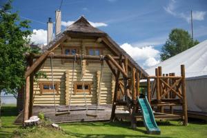 a playground in front of a log cabin at Järveveere Puhkekeskus in Valma