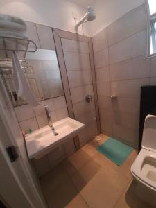 La salle de bains est pourvue d'un lavabo et d'une douche avec un miroir. dans l'établissement D2W Residency Suites, à Nairobi