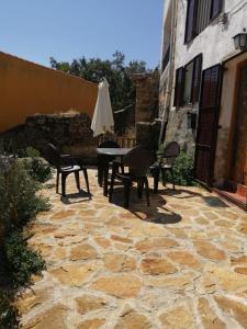 a patio with a table and chairs and an umbrella at Los Castaños in Solana de ávila