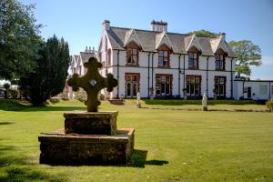 a statue in front of a house with a cross at The Ennerdale Country House Hotel ‘A Bespoke Hotel’ in Cleator