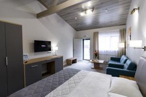 Cette chambre comprend un lit, une télévision et un canapé. dans l'établissement Inter Hotel, à Samara
