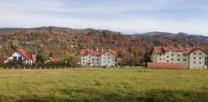 a group of buildings in a field with a grass field at Apartament Margarita "OZONOWANY" in Wisła