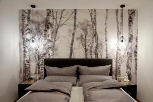 a bedroom with a black and white forest mural at see.view apartment in See