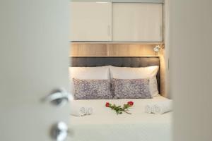 een slaapkamer met een bed met twee rozen erop bij Eden Mediterranean House in Vrsine