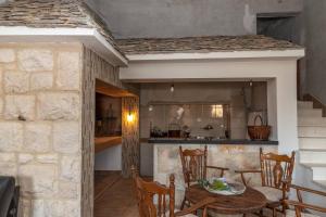 een keuken en eetkamer met een tafel en stoelen bij Eden Mediterranean House in Vrsine