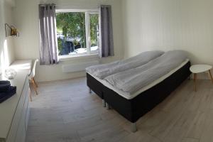 Un dormitorio con una cama grande y una ventana en I hjerte av Åndalsnes sentrum en Åndalsnes