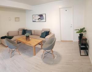 uma sala de estar com um sofá, uma mesa e cadeiras em I hjerte av Åndalsnes sentrum em Åndalsnes