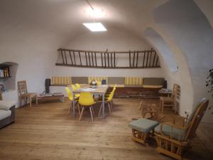 a dining room with a table and yellow chairs at Ostello del Monastero in Dronero
