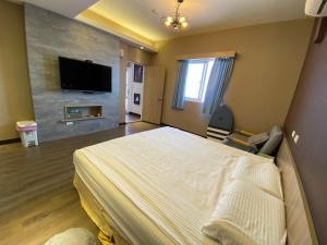 a bedroom with a large bed and a flat screen tv at I WoW in Xiaoliuqiu