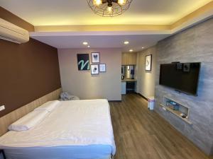 a room with a bed and a flat screen tv at I WoW in Xiaoliuqiu