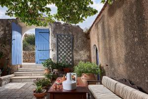 patio con puerta azul y mesa con sofá en Philyra Farmhouse en Epáno Kefalás