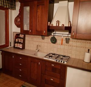 a kitchen with wooden cabinets and a stove top oven at Charme & Relax a Rivisondoli in Rivisondoli