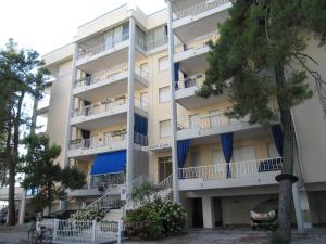 an apartment building with balconies and trees at Appartamento Ariston in Lido