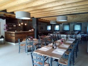 un restaurant avec des plafonds en bois, des tables et des chaises dans l'établissement Agriturismo Corte Maccini, à Vérone