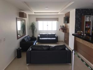 a living room with black couches and a window at Guines Palace Hotel in Patrocínio