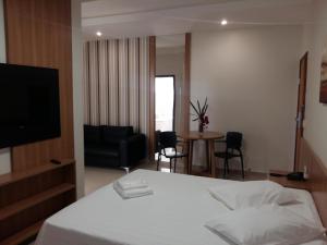 a hotel room with a bed and a table and chairs at Guines Palace Hotel in Patrocínio
