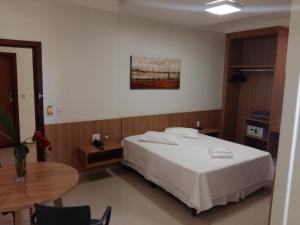 a hotel room with a bed and a table at Guines Palace Hotel in Patrocínio