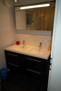 a bathroom sink with two faucets and a mirror at Ferienwohnung Meding am See in Schondorf am Ammersee