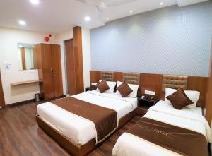 a hotel room with two beds in a room at Hotel Airside in Mumbai