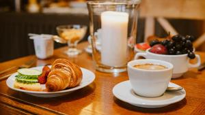 a table with plates of food and a cup of coffee at Kaķītis in Sigulda