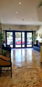 eine Lobby mit einem großen Zimmer mit Sofa und Stühlen in der Unterkunft H&L Hotel in Cinisello Balsamo