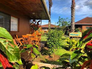 a yard with chairs and a house at Marae - Cabañas Premium in Hanga Roa