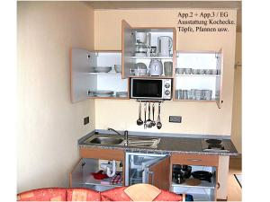 eine Küche mit Spüle und Mikrowelle in der Unterkunft Järgen Ferienappartements in Koblenz
