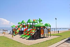 um parque infantil na praia com um escorrega aquático em Villaggio Turistico Europa em Grado