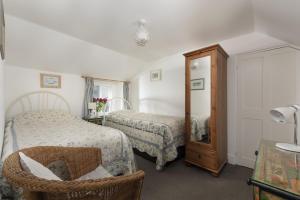 a hotel room with two beds and a mirror at Trevara, Marazion in Marazion