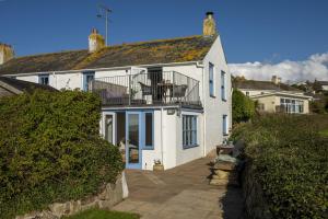 a white house with a balcony on top of it at Trevara, Marazion in Marazion
