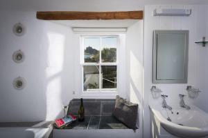 a bathroom with a sink and a tub and a window at Trevara, Marazion in Marazion +29 photos