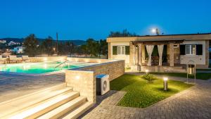 een villa met een zwembad en een huis bij Lando Resort in Rab