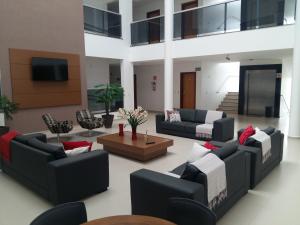 a large living room with couches and a tv at Guines Palace Hotel in Patrocínio