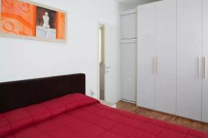 a red bed in a white room with a red blanket at Red House ai Mori in Venice +4 photos
