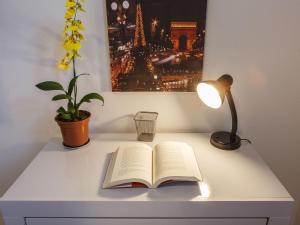 een open boek op een bureau met een lamp bij Apartamento com quintal em Alto de Pinheiros in Sao Paulo